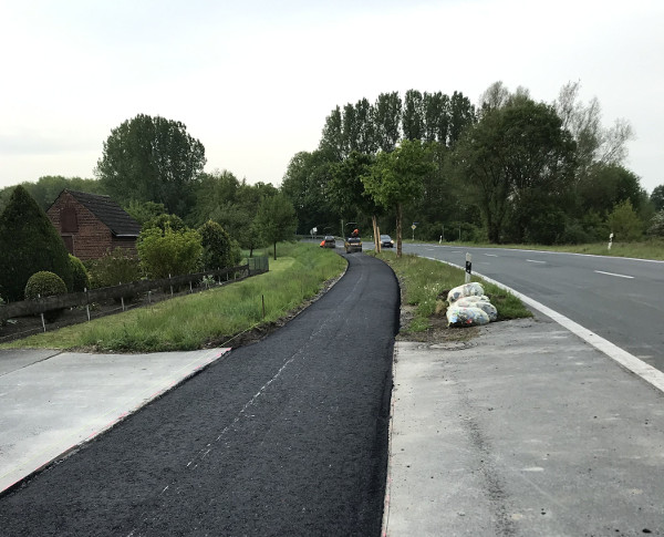 Hier ist die erste Asphaltschicht bereits eingebaut. Nach Aufbringung der feineren Deckschicht können Fahrräder den Weg wieder komfortabel nutzen. Maroder Radweg wird saniert